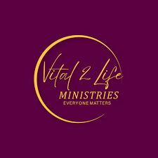 The image displays the logo for "Vital 2 Life Ministries." The logo features gold-colored text and a crescent shape on a dark purple background. The text reads "Vital 2 Life" in cursive and "MINISTRIES" and "EVERYONE MATTERS" in capital letters below it.